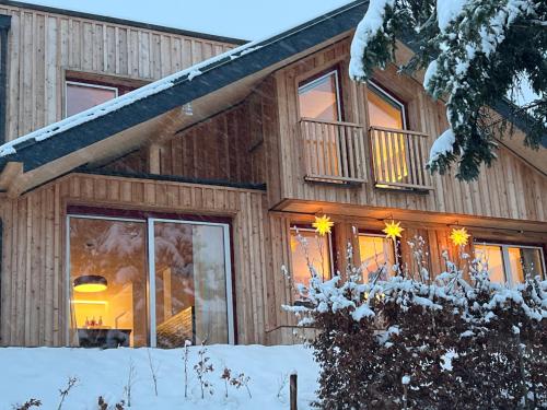a wooden house with snow in front of it at Feldhasen in Bad Ischl