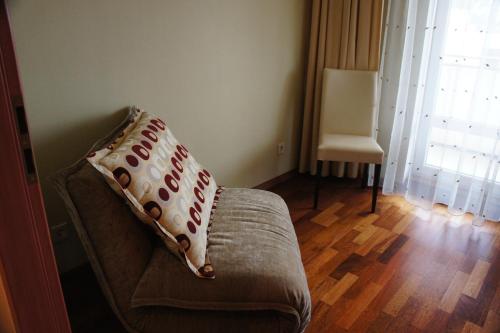 a couch with a pillow on it in a living room at Lyra Apartments in Druskininkai