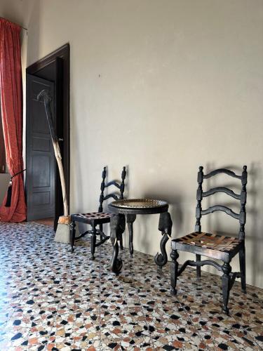 um quarto com duas cadeiras e uma mesa e uma mesa em Palazzo del Settecento em Ravenna