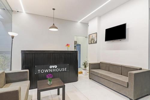 a living room with a couch and a tv at Townhouse Ameerpet in Ameerpet