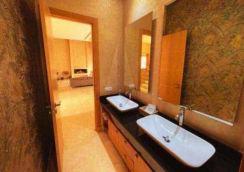 a bathroom with two sinks and a large mirror at Cozy Villa With Pool and Indoor Fireplace in Casablanca