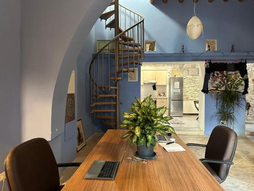 a dining room with a table and a spiral staircase at Teleport Coliving Cyprus in Pano Lefkara
