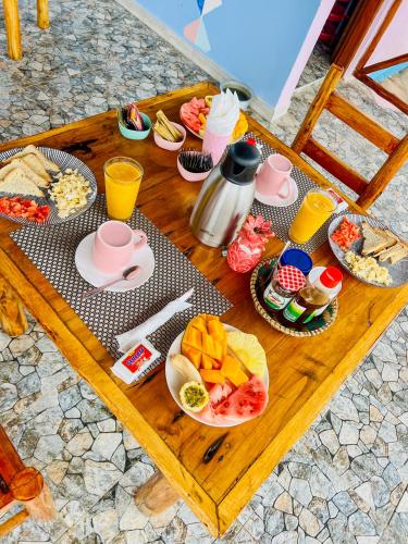 a table with a bunch of breakfast foods on it at Pineapple House in Nungwi
