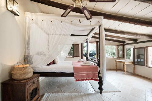 a bedroom with a canopy bed in a room at Villa Can Ros in Capdellá