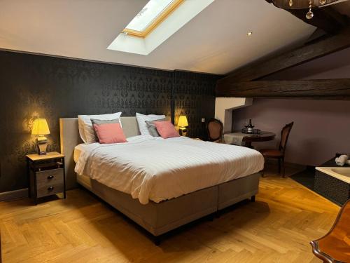 ein Schlafzimmer mit einem großen Bett mit rosa Kissen in der Unterkunft Pax et Amor Chambres d'hôtes de charme - Charming B&B in Mazerolles-du-Razès