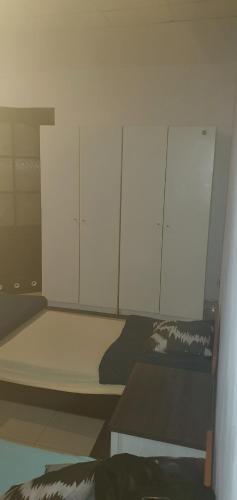a bedroom with a bed with white cabinets at Noclegi pracownicze in Tomaszów Mazowiecki