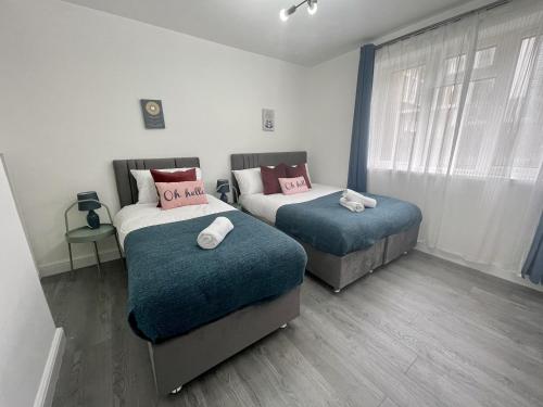 two beds in a room with two pillows at Deluxe Apartment - Next to Kings Cross - Eurostar & Euston Station in London