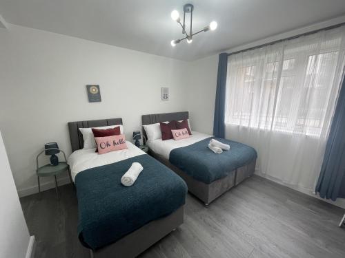 1 dormitorio con 2 camas y ventana en Deluxe Apartment - Next to Kings Cross - Eurostar & Euston Station, en Londres