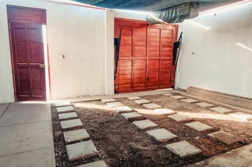 una habitación vacía con una puerta roja y algo de suciedad en Verano en Boca del Río en La Boca del Río