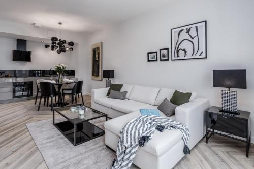 a living room with a white couch and a table at DEO PLAZA - Apartments at the Old Town in Gdańsk