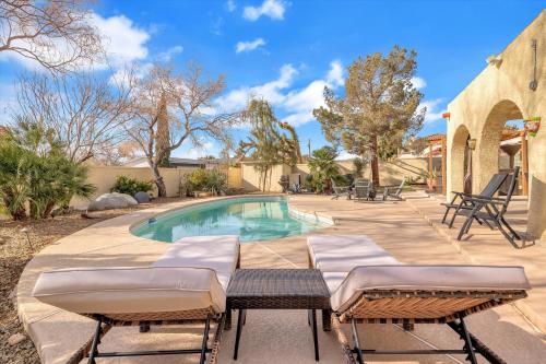 a swimming pool with chaise lounge chairs and a swimming pool at Ranch style villa with pool and spa in Las Vegas