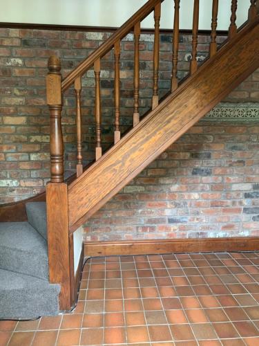 a wooden staircase with a brick wall at Pear Tree House 2 bed apartment in Hartford