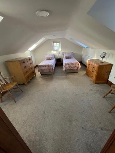 Zimmer im Dachgeschoss mit 2 Betten, einem Tisch und Stühlen in der Unterkunft Pear Tree House 2 bed apartment in Hartford