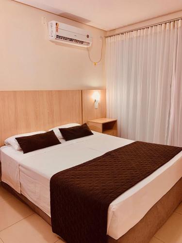 a bedroom with a large bed and a air conditioner at Victoria Plaza Hotel in Palmas