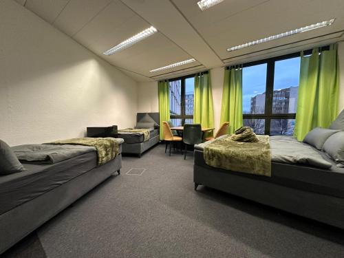 a bedroom with two beds and a room with a window at Pension Bavaria Immobilien in Nuremberg