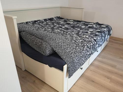 a white bed with a black and white comforter at Lovely one bedroom condo next Mall Vitan in Bucharest