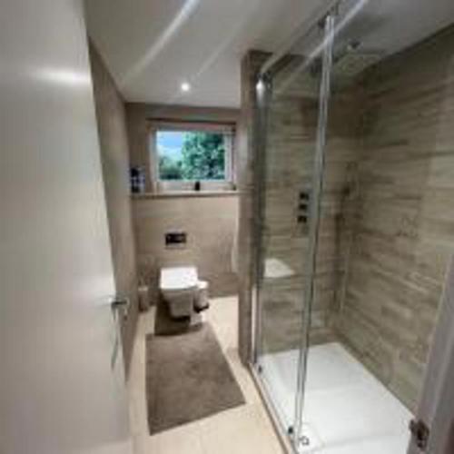 een badkamer met een glazen douche en een toilet bij Inviting 4-Bed House in Finchley London in Hendon