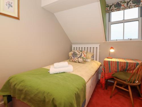 een kamer met 2 bedden, een stoel en een raam bij The Roses in Windermere