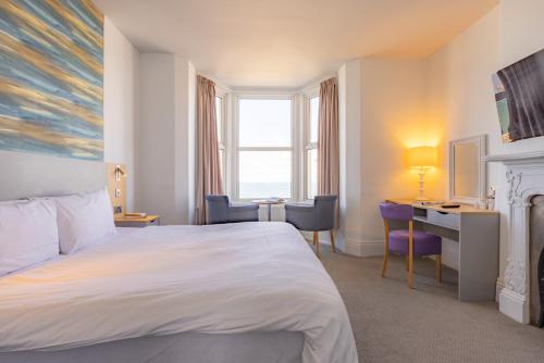 a hotel room with a bed and a desk at The Seafront Hotel by Compass Hospitality in Llandudno