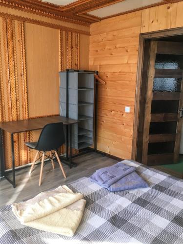 a bedroom with a bed and a desk and a chair at Shum Cheremosha in Verkhovyna