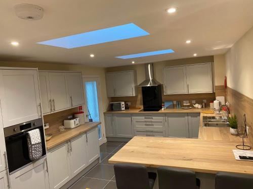 a kitchen with white cabinets and a blue skylight at Beldorny in Kingston