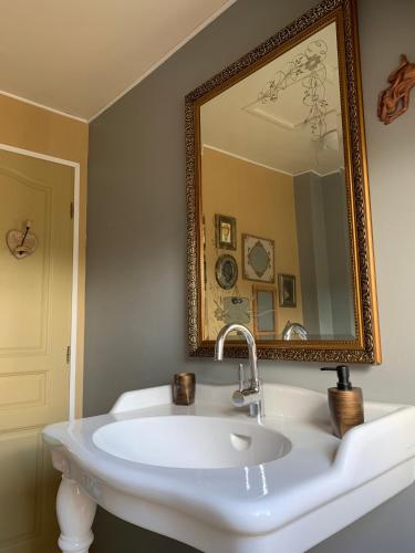 une salle de bain avec un lavabo blanc et un miroir dans l'établissement Bocage et Coquillage, à Gouville-sur-Mer
