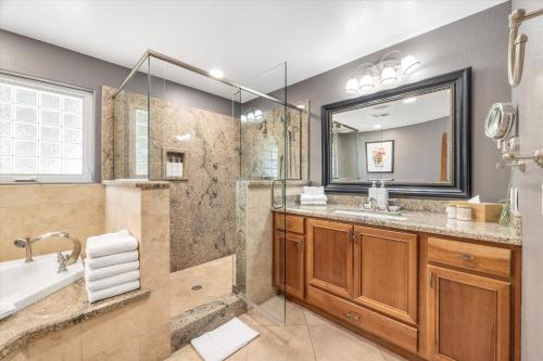 a bathroom with a tub and a sink and a mirror at Luxury villa with pool and spa in Las Vegas