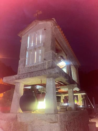 a stone tower with a cross on top of it at night at Os Fentos in Pontevedra