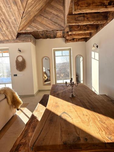 a room with a large wooden table in a room with windows at Dabintos slėnis in Sumiliszki