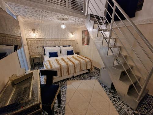 a bedroom with a bed and a spiral staircase at Riad Explore in Marrakesh