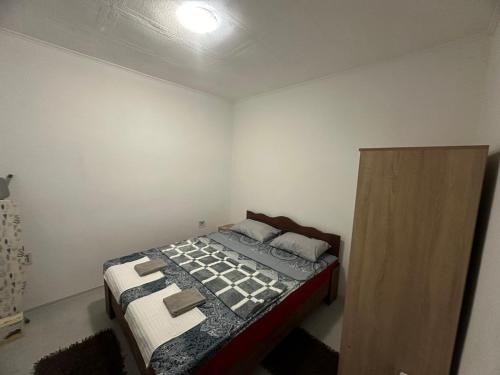 um quarto com uma cama e um armário de madeira em Apartman DALT em Trebinje