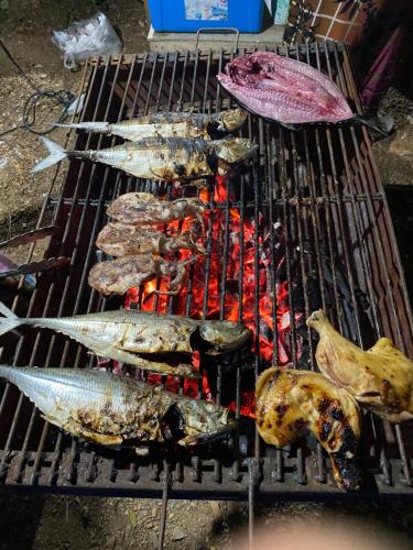 ein Haufen Fisch auf einem Grill in der Unterkunft Lanta natural hut garden in Phra Ae beach