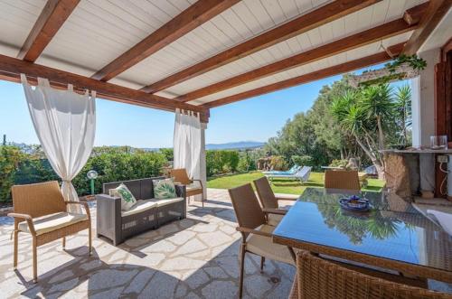 an outdoor patio with a table and chairs at Bellavista Vacation in Olbia