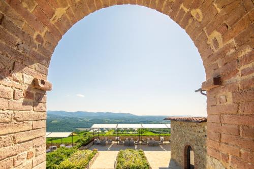 an archway in a building with a view of a courtyard at The Club House in Castelnuovo Berardenga