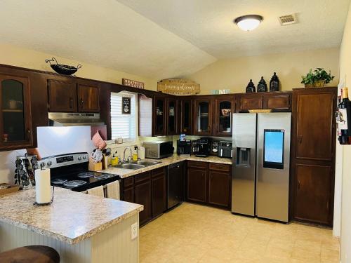 a kitchen with wooden cabinets and stainless steel appliances at Cozy quiet retreat. in Beaumont