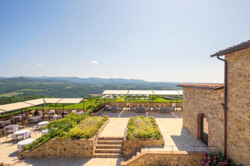 a view of a patio with tables and chairs at The Club House in Castelnuovo Berardenga