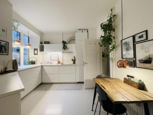 a kitchen with white cabinets and a wooden table at ApartmentInCopenhagen Apartment 1584 in Copenhagen