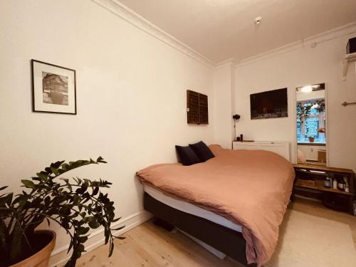 a bedroom with a bed and a potted plant at ApartmentInCopenhagen Apartment 1584 in Copenhagen