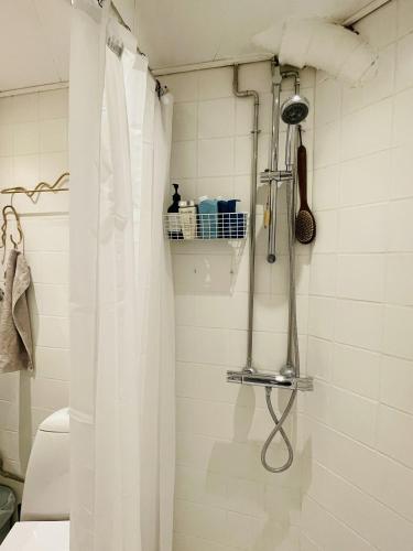 a shower with a white shower curtain in a bathroom at ApartmentInCopenhagen Apartment 1584 in Copenhagen