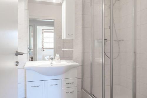 uma casa de banho branca com um lavatório e um chuveiro em Stranach Appartements em Sankt Michael im Lungau