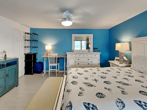 a bedroom with blue walls and a bed and a desk at Madeira Beach Yacht Club 323b in St. Pete Beach
