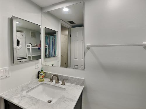 a bathroom with a sink and two mirrors at Madeira Beach Yacht Club 323b in St Pete Beach