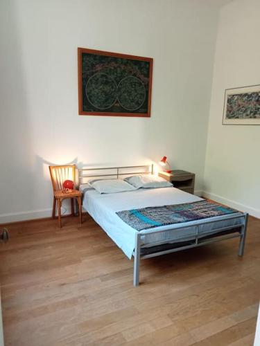 une chambre avec un lit et une chaise dedans dans l'établissement Ancienne Gare rénovée, à Mareuil-sur-Belle