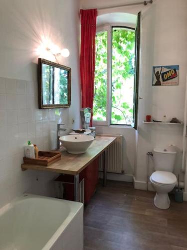 une salle de bain avec un lavabo, des toilettes et une baignoire dans l'établissement Ancienne Gare rénovée, à Mareuil-sur-Belle