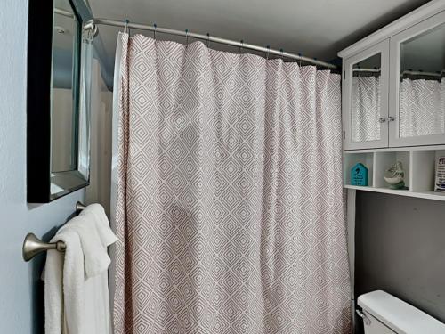 a bathroom with a shower curtain and a sink at Villa Del Sol 1145 - Mermaids Hideaway in Corpus Christi