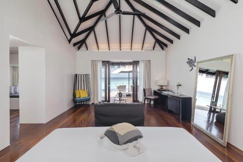 a bedroom with a bed and a view of the ocean at Noku Maldives in Manadhoo