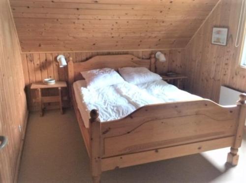 a bedroom with a wooden bed in a room at Cozy Holiday cottage at Ringkøbing Fjord in Hemmet
