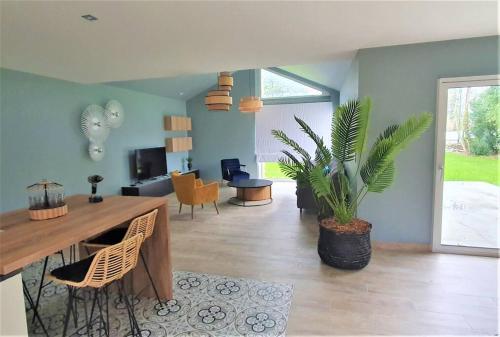 un salon avec une table et une plante dans l'établissement La Longère de Marie - Gîtes de Kerblaise, à Concarneau