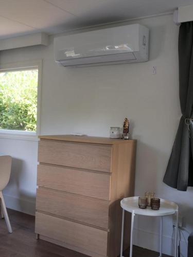 a room with a chest of drawers and a table at Gezellige Chalet met airco en vele faciliteiten! in Baarle-Nassau