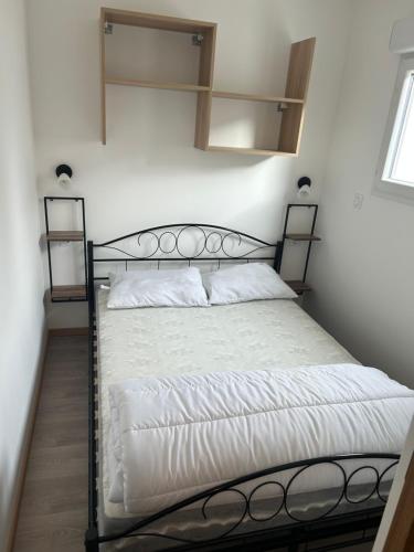 1 dormitorio con cama negra con sábanas blancas en Bienvenu chez nous en Douzens